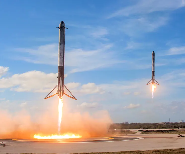 Two Falcon Heavy side boosters landing side by side at Cape Canaveral in February 2018