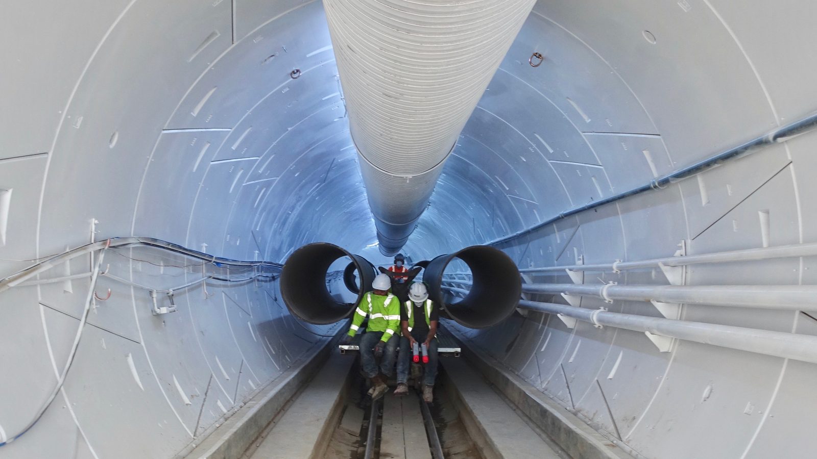 Workers ride a rail cart through the finished Hawthorne test tunnel in December 2018