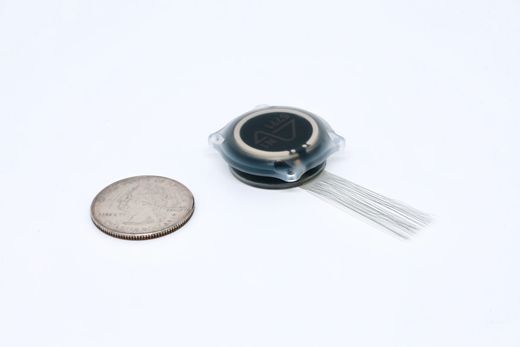 Neuralink N1 implant next to a U.S. quarter