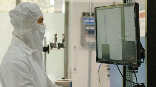 Neuralink technician reviewing camera feeds in a cleanroom