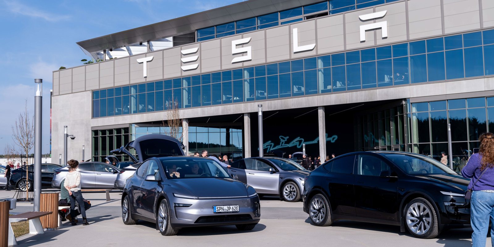 Gigafactory Berlin exterior with the TESLA sign and Model Y vehicles in the plaza
