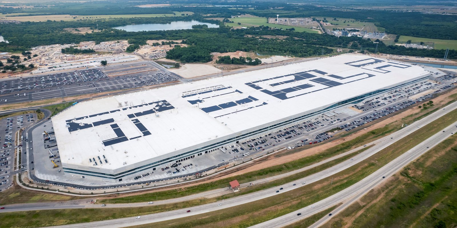 Completed Gigafactory Texas aerial with TESLA spelled in solar panels on the finished roof
