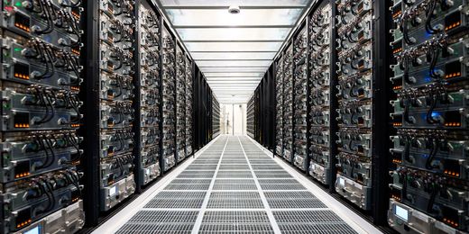 Interior corridor of a Tesla Megapack site lined with battery modules and orange connectors
