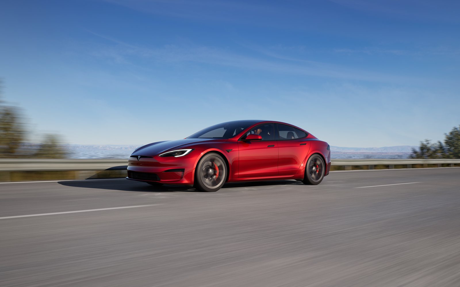 Tesla Model S Plaid in Ultra Red on a coastal highway