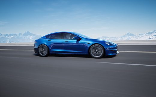 Blue Tesla Model S on a mountain highway, side view
