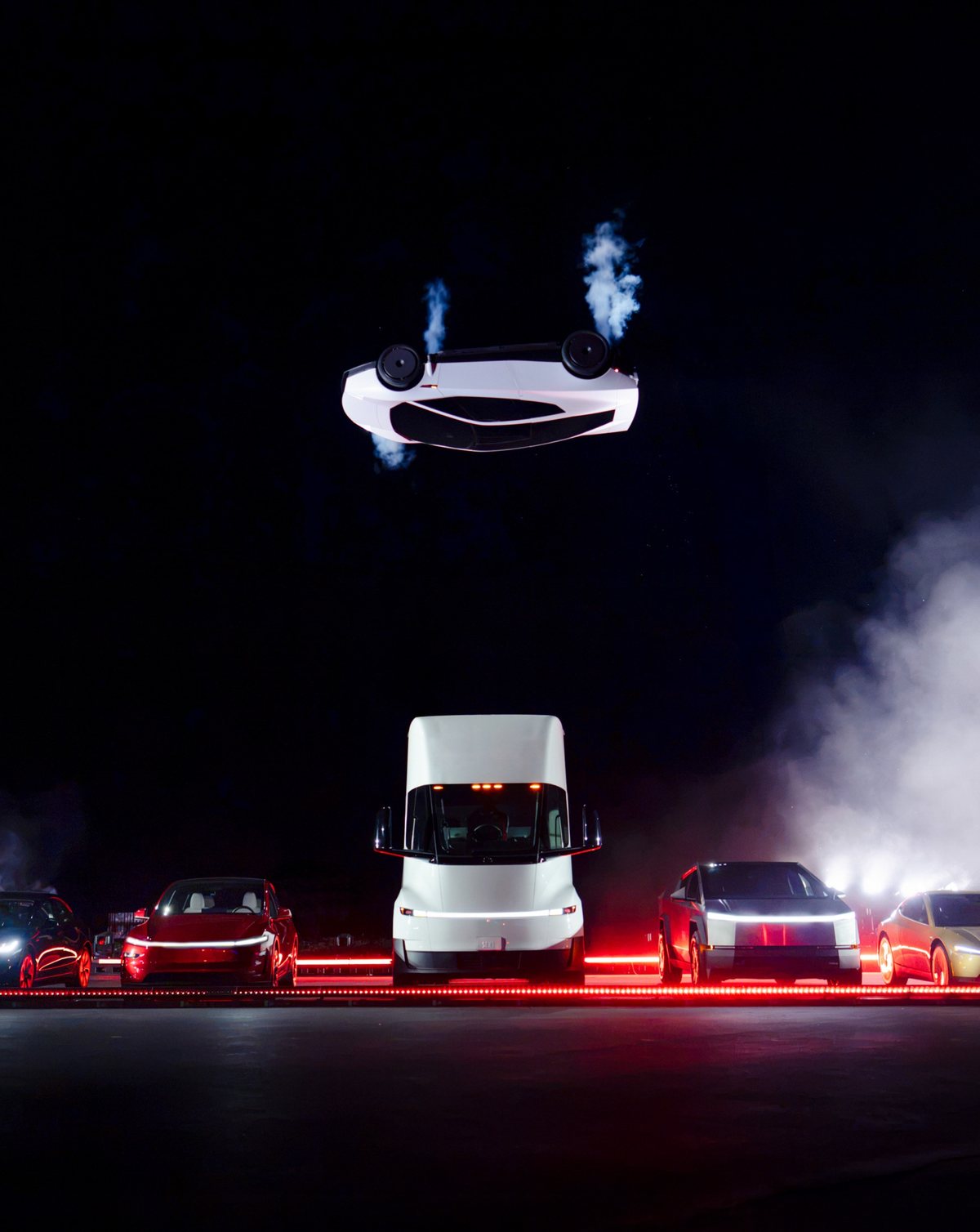 The 2026 Tesla Roadster upside down in the air above a Tesla Semi and a row of Teslas