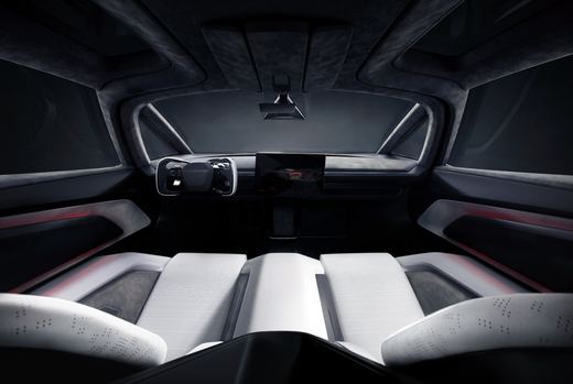 Cabin of the 2026 Tesla Roadster seen from behind its two white seats, with a yoke and a center touchscreen