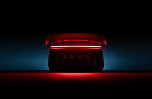 Rear of the 2026 Tesla Roadster lit red, showing its full-width taillight and a row of round thruster ports